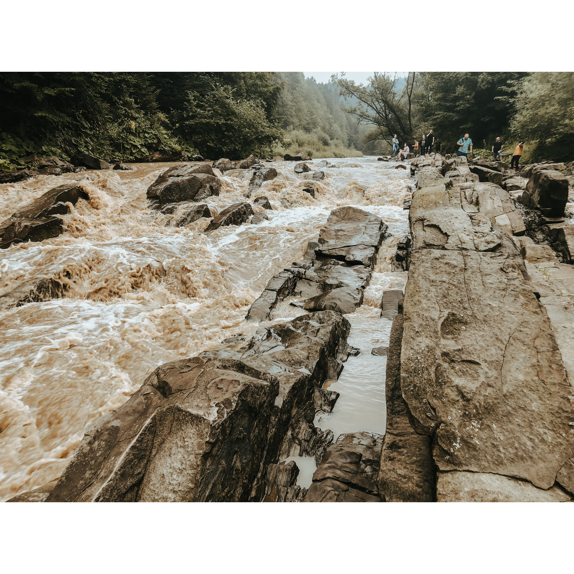 Wzburzony nurt rzeki uderzający o kamienie 