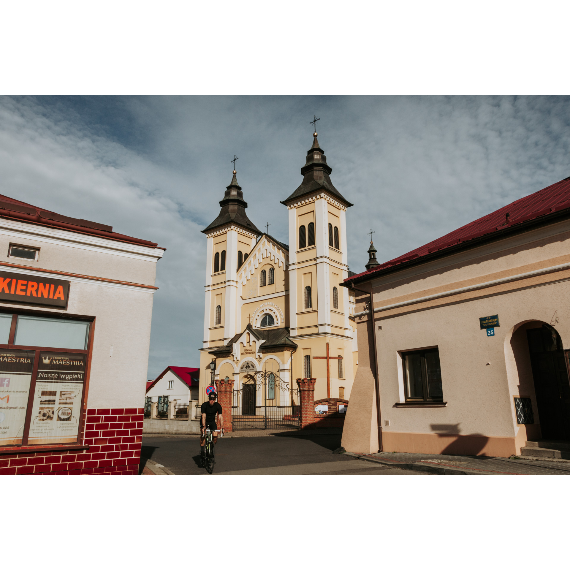 The center of the city market - in the middle a brick church with a cream façade with two tall towers topped with dark domes, around other utility buildings