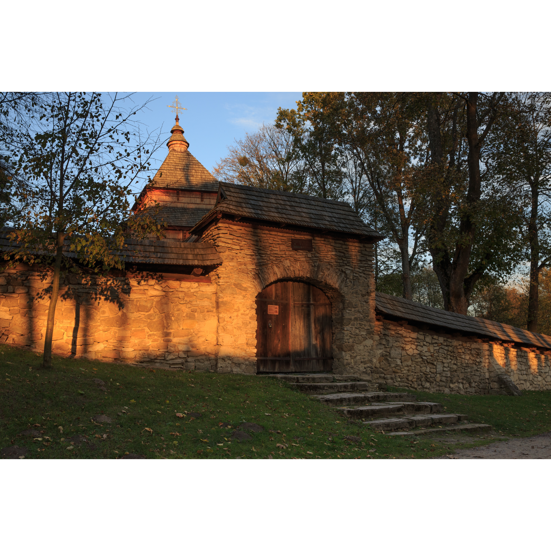 Stone gate with wooden door and roof and stone stairs