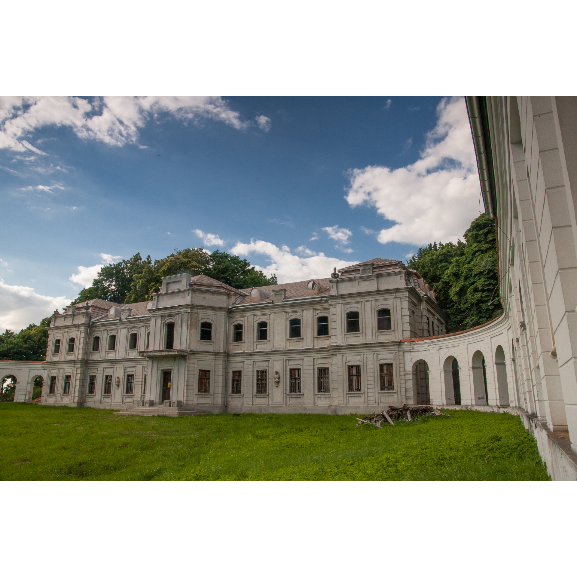 A bright, abandoned palace with many windows on two floors