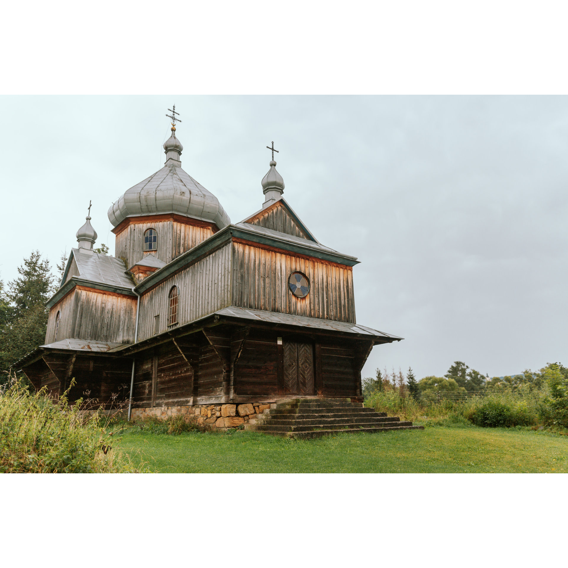 A wooden church with one main dome and two smaller ones