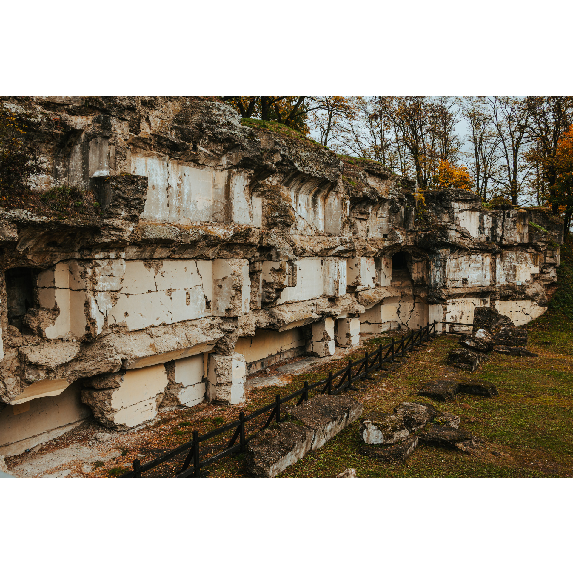 Destroyed side wall of a concrete fort covered with moss