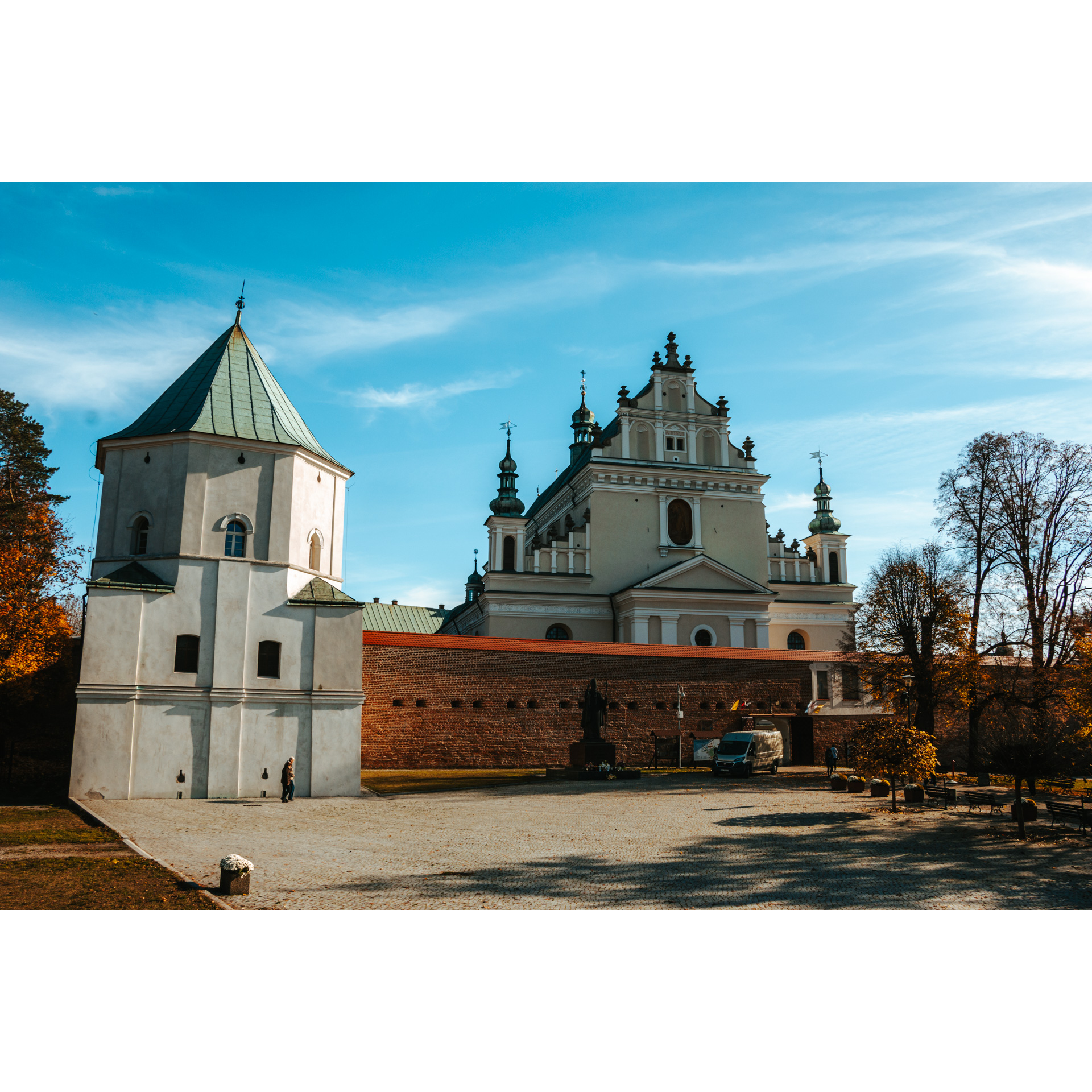 The upper facade of the monastery from behind a brick wall