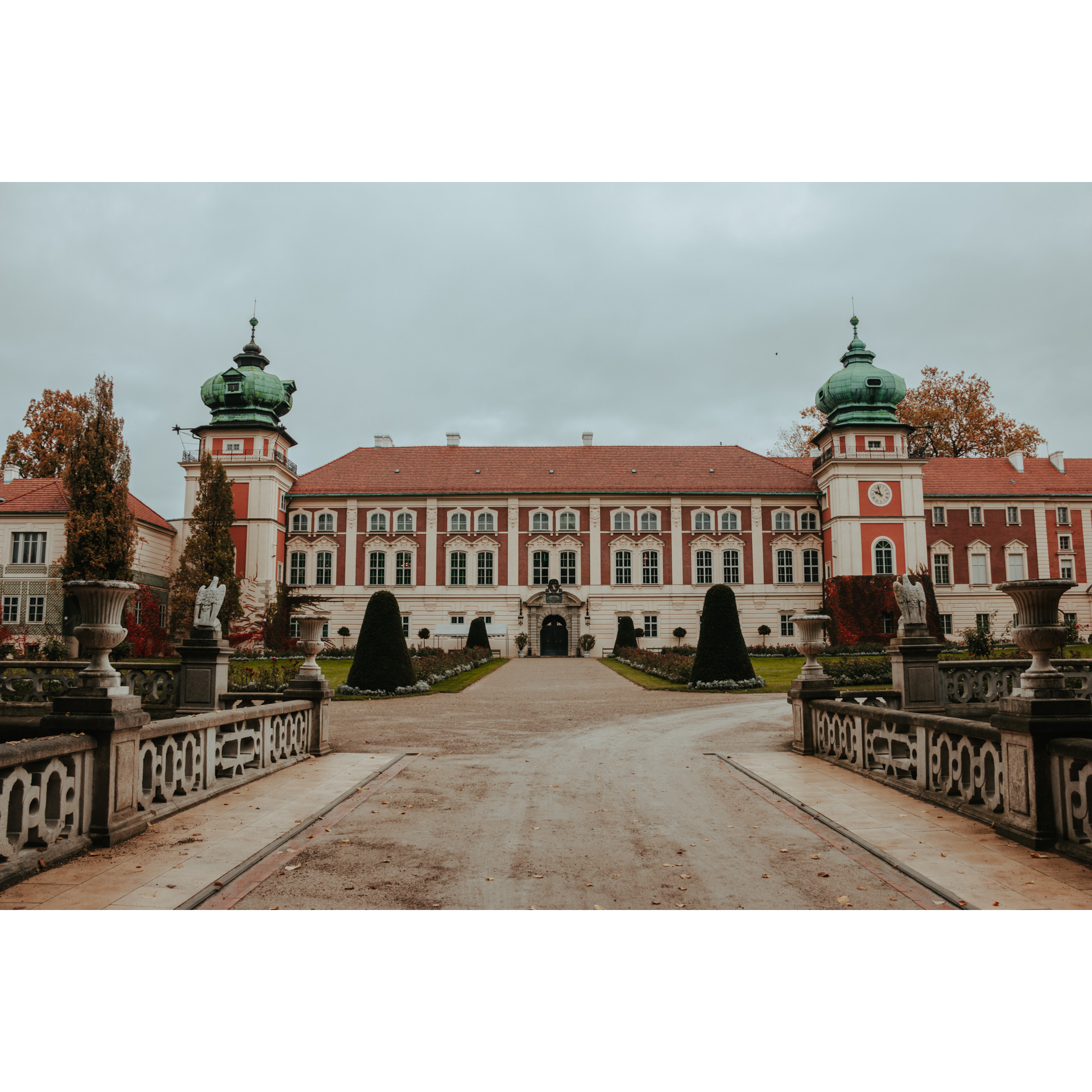 Entrance road to the beige and red castle with green domes