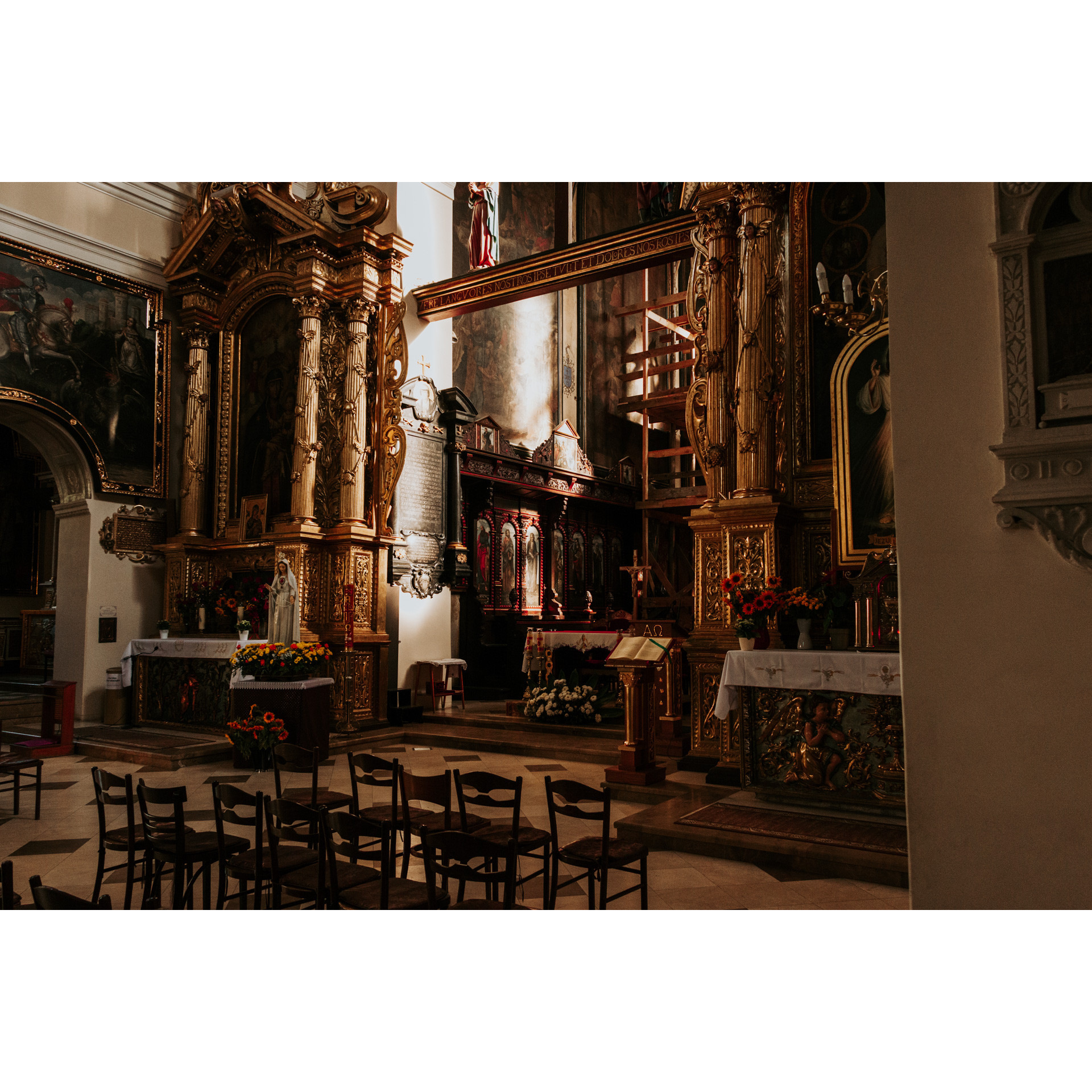 The altar inside the church with gold and red trim and holy images