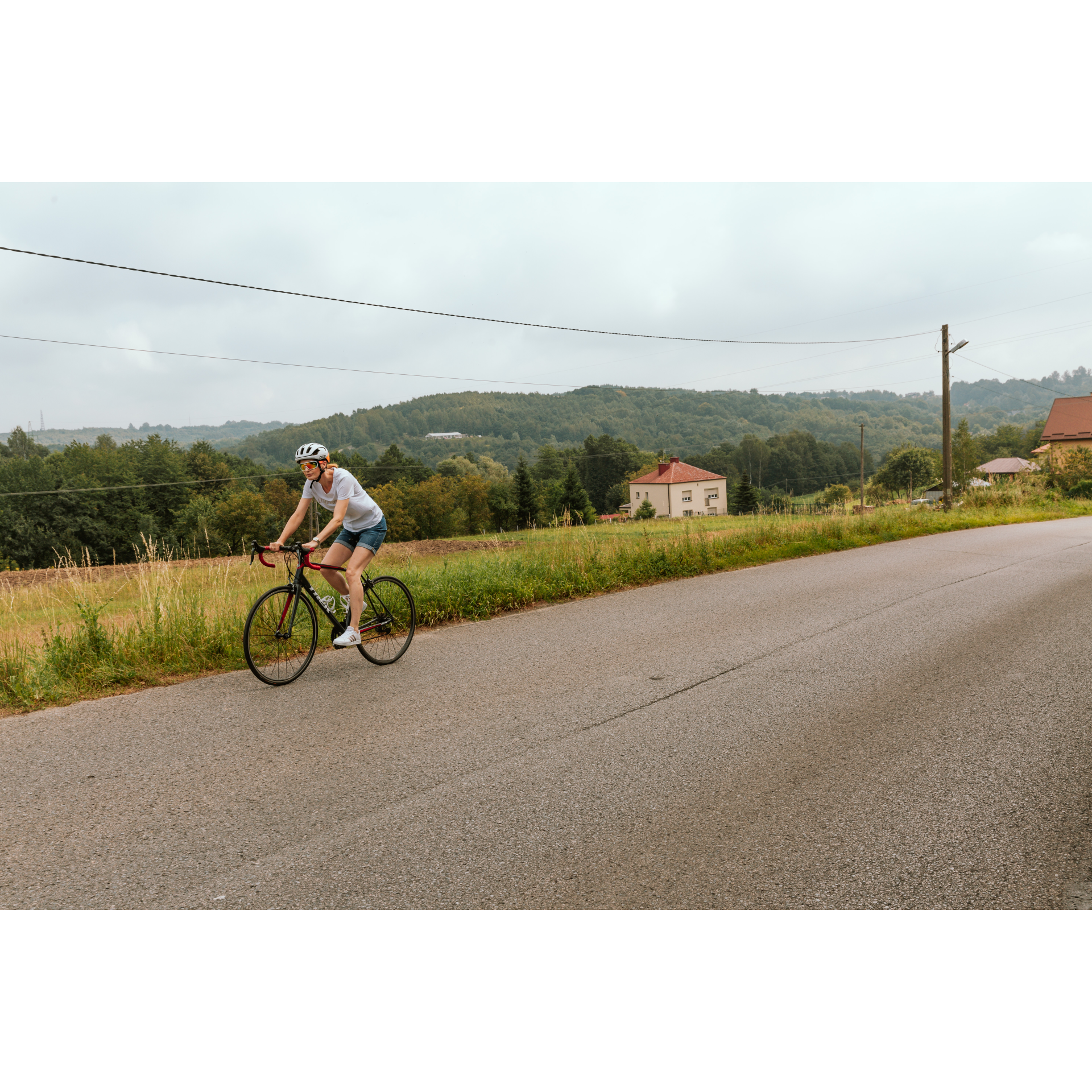 A cyclist and hills and houses in the background