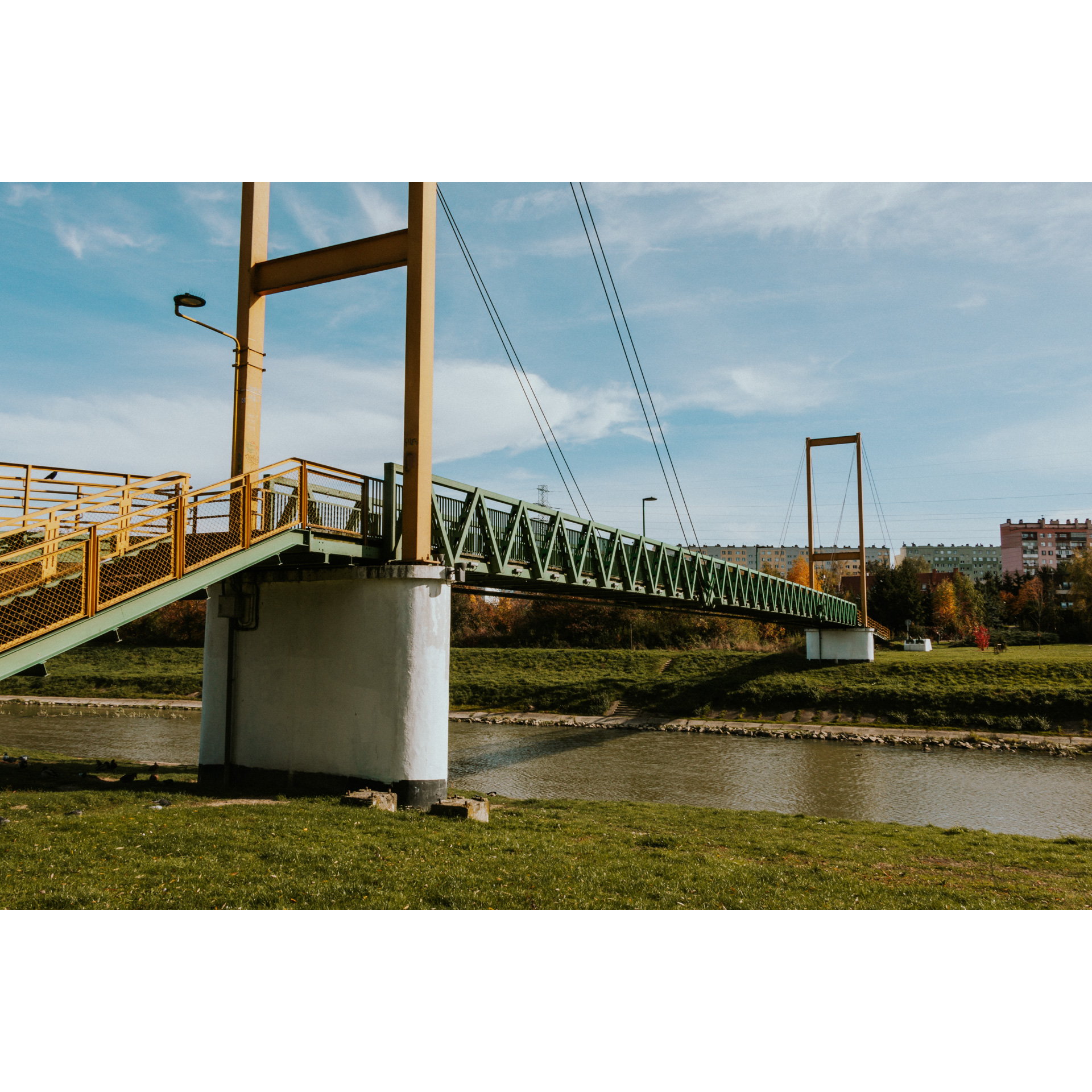Pedestrian bridge over the river with a green railing
