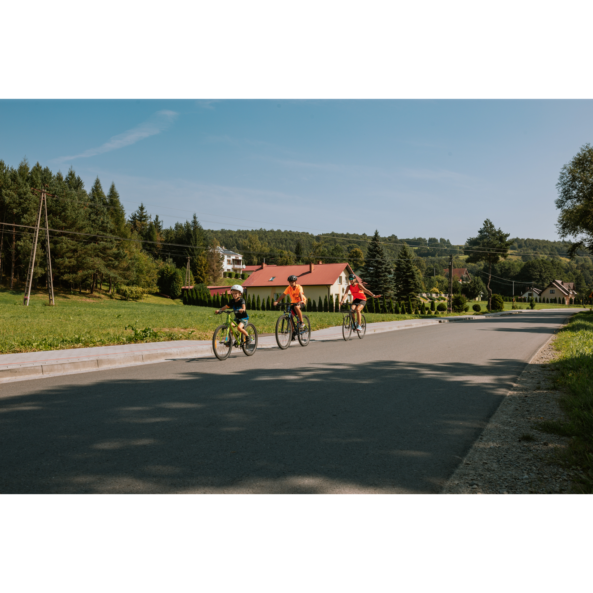 Rowerzyści i dom z czerwonym dachem