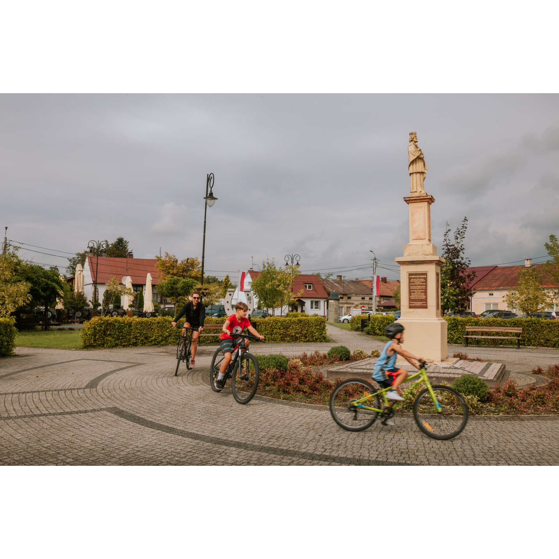 Cyclists on the square with a monument