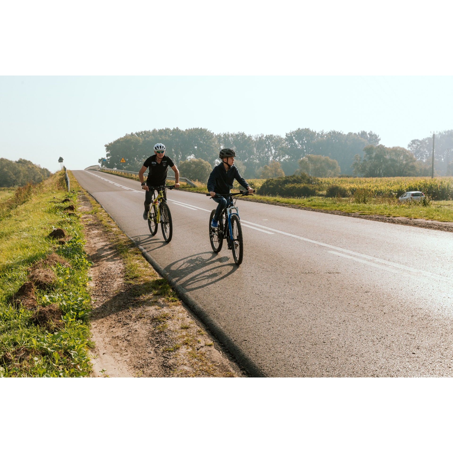 Dwóch rowerzystów na asfaltowej drodze