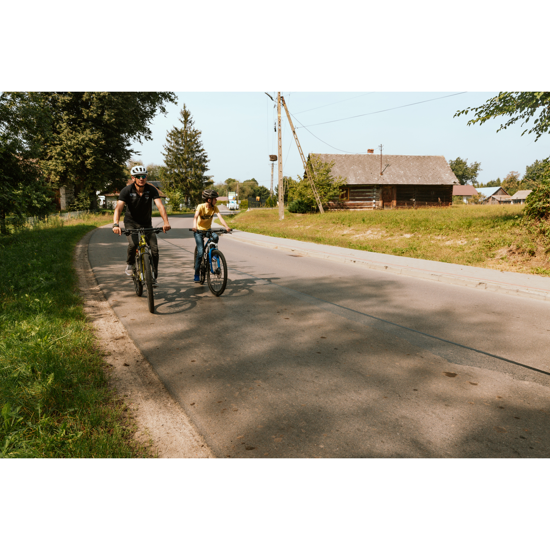 Cyclists and a wooden house