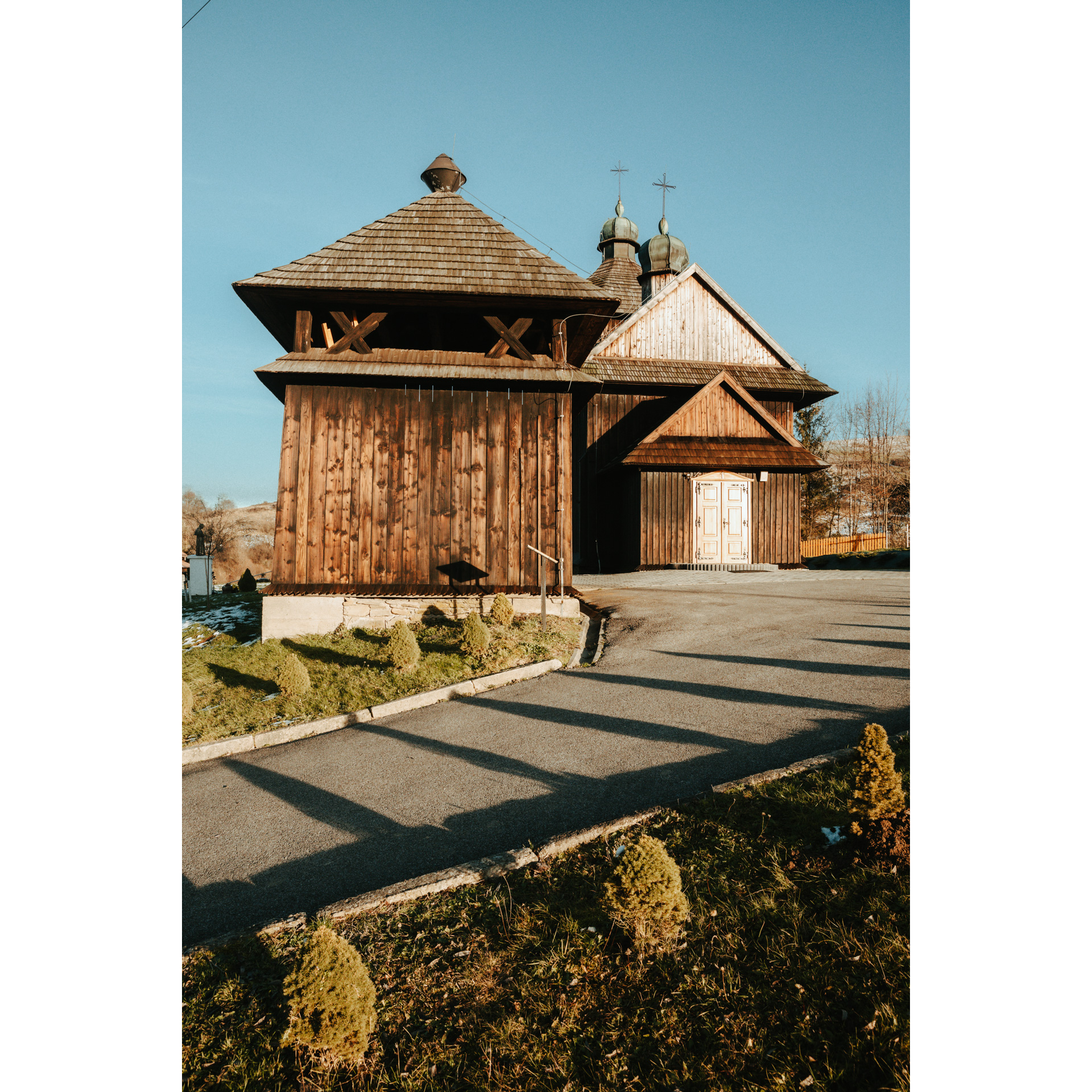 A wooden church with two turrets with a domed roof surmounted by crosses