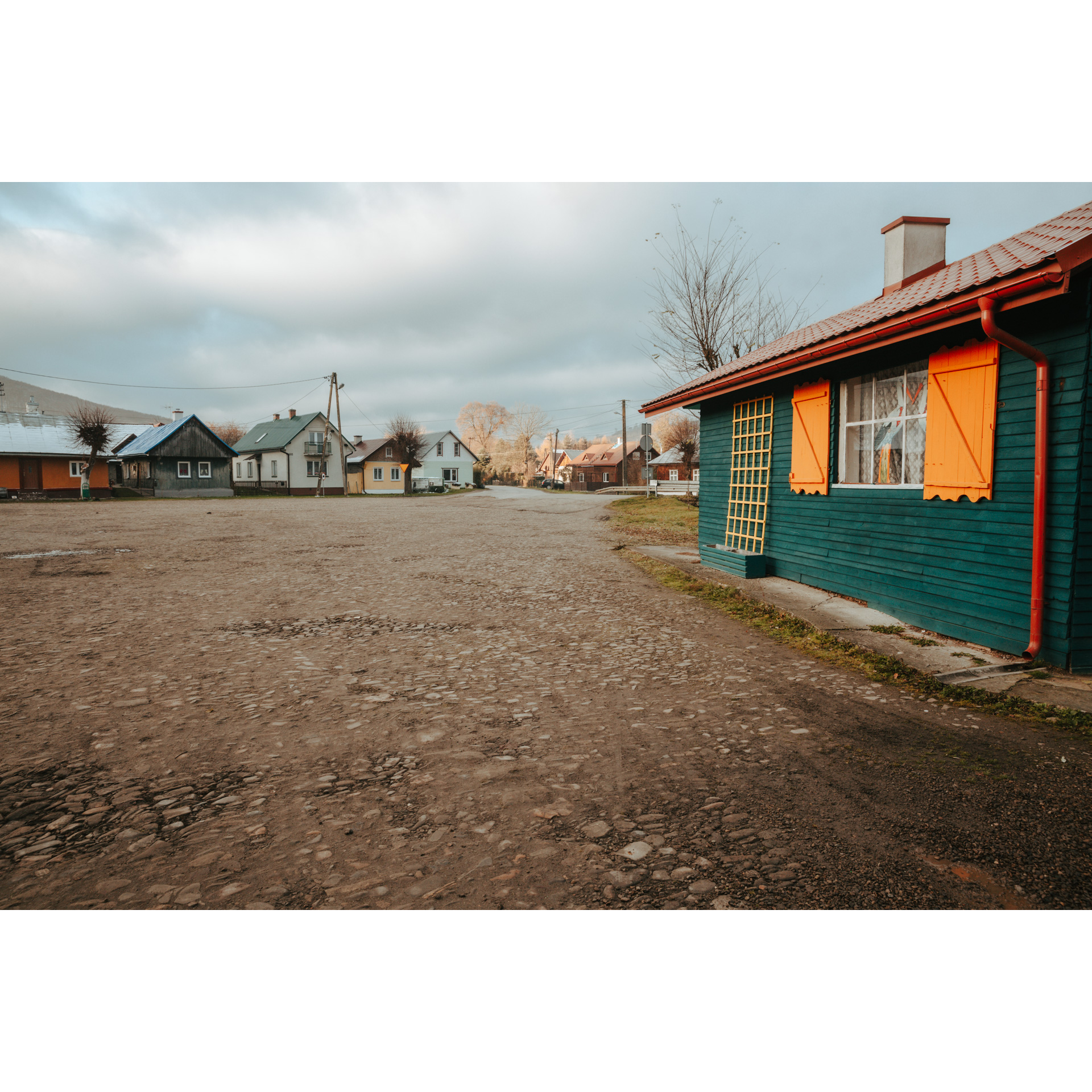 A stony country road running between colorful wooden houses