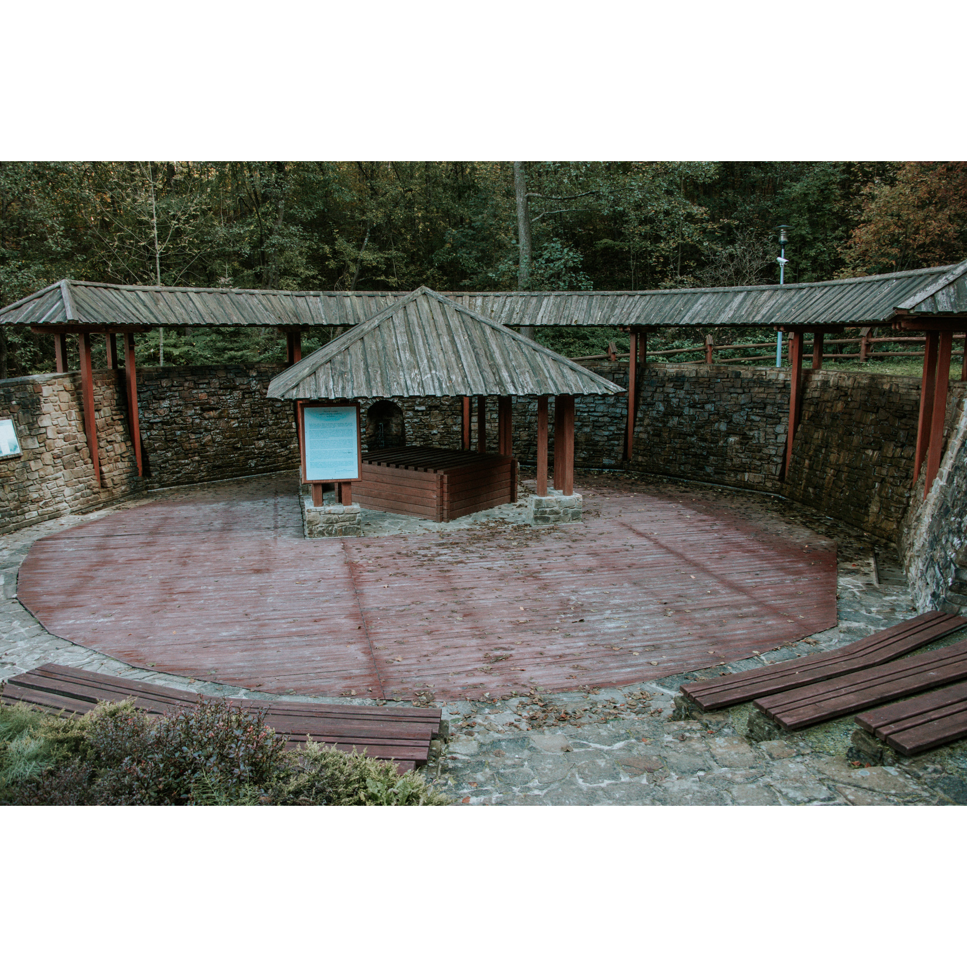 Salt graduation tower with a well in the middle standing on a wooden platform in the shape of a circle, surrounded by a wall on which water flows