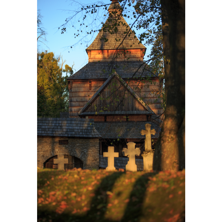 Stone crosses against the background of an old wooden church