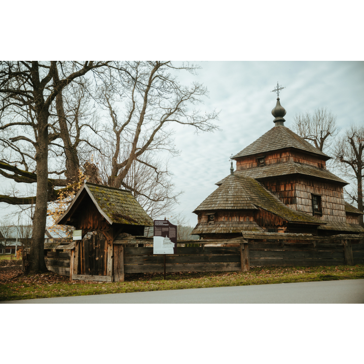 Drewniana cerkiew otoczona drewnianym płotem z bramą wejściową