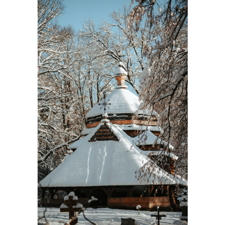 Snow-covered wooden church among forest trees