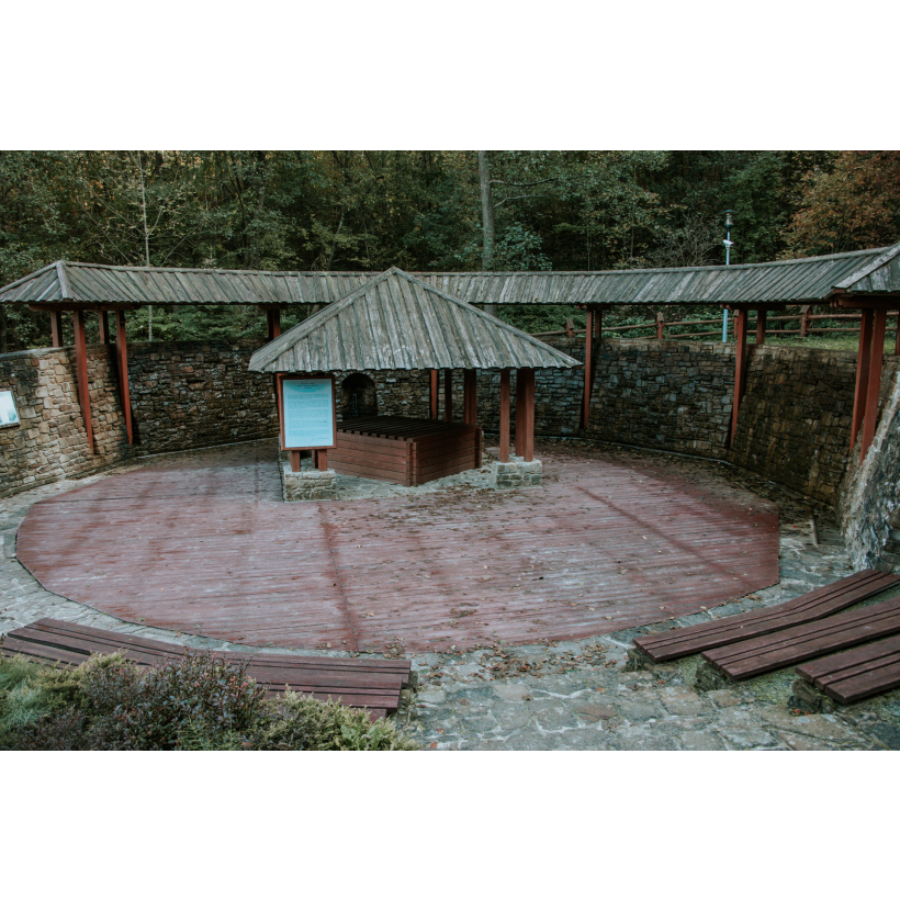 The shed is surrounded by a stone wall on a round wooden platform