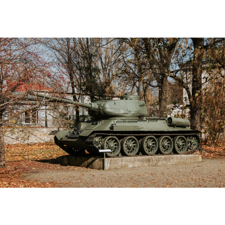 A tank standing on a stone base among autumn trees and leaves