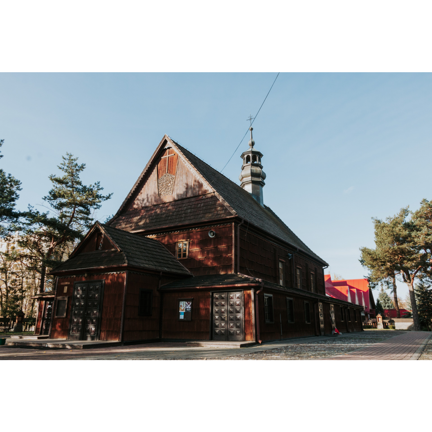 A small wooden church with ornate doors and a cross in the facade