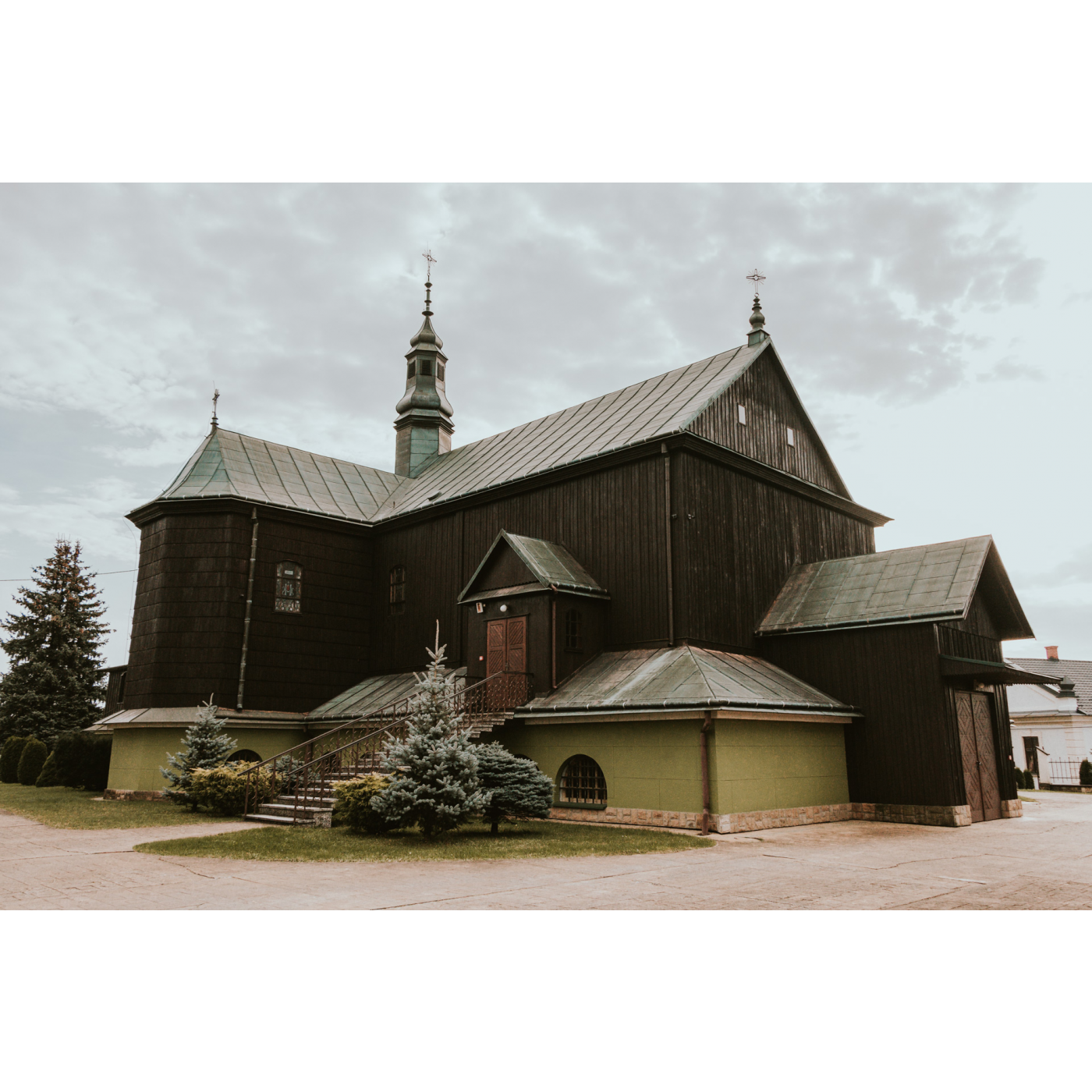 A wooden church with a high foundation and long stairs leading to the entrance