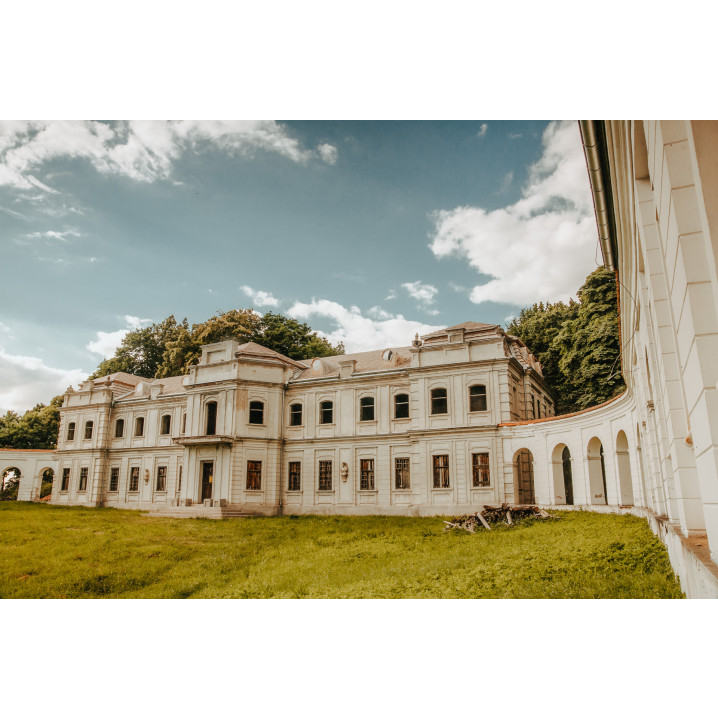 A bright, abandoned palace with many windows on two floors