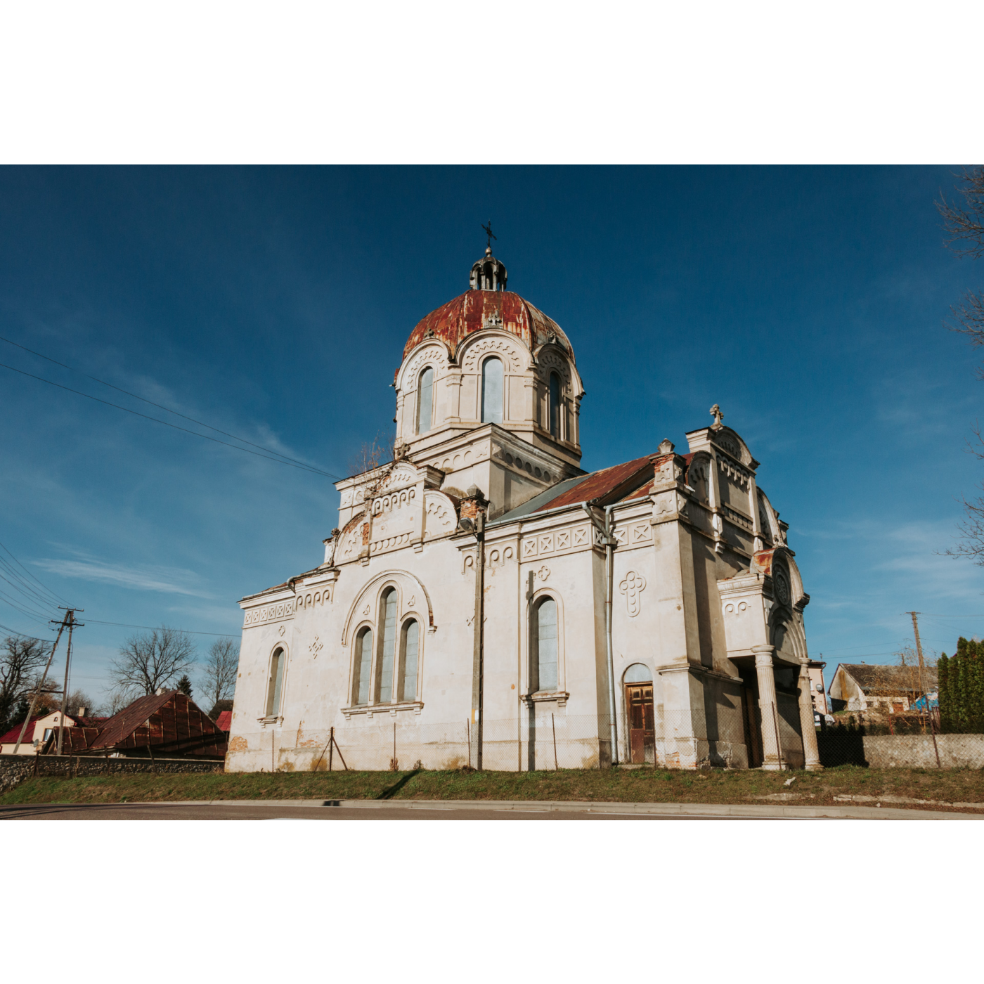 Jasna, murowana cerkiew z ozdobnymi oknami i kopułą