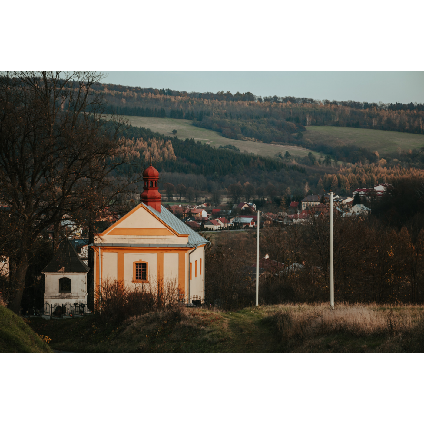 An orange-beige Orthodox church against the backdrop of single-family buildings